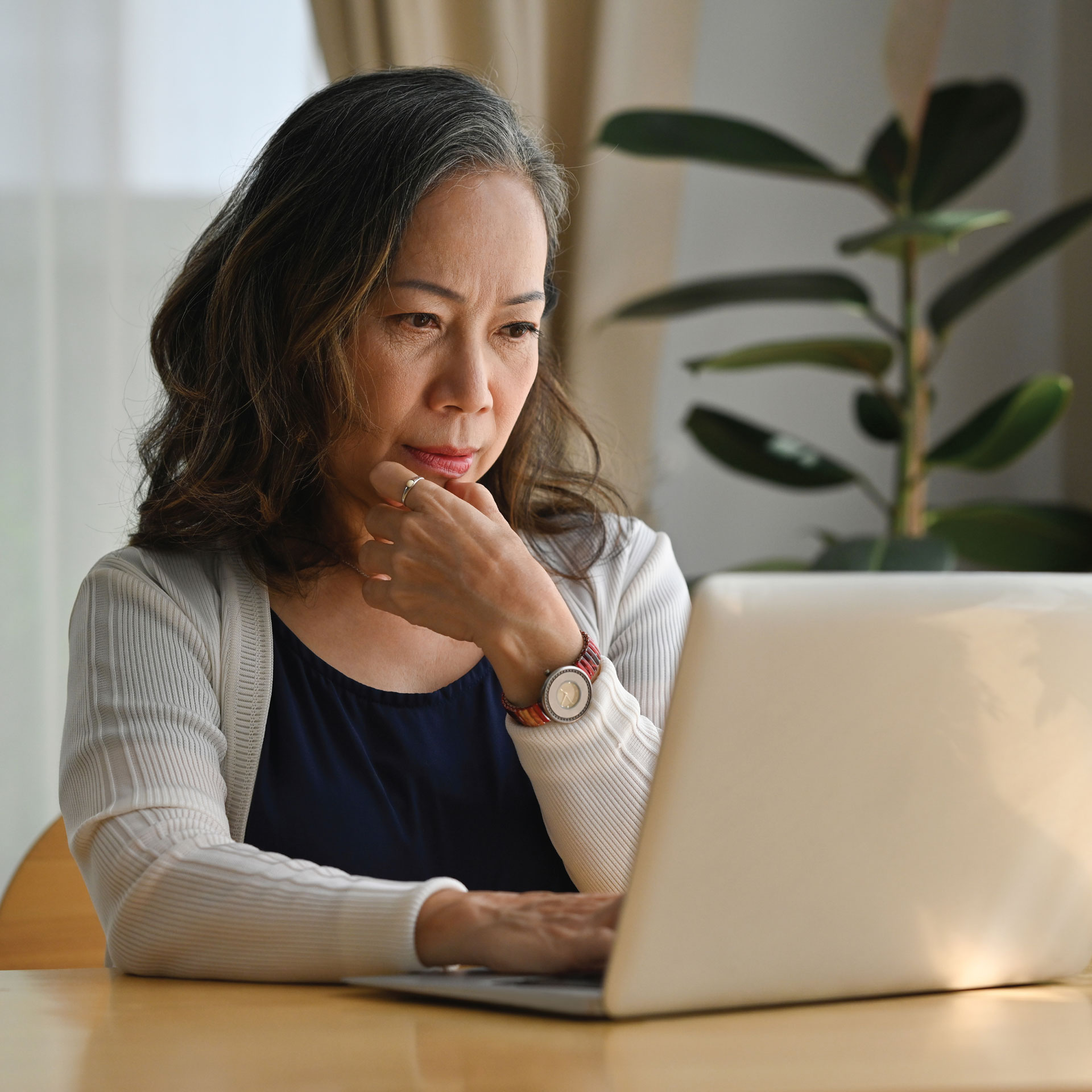 Person at home working on a laptop at a table.
