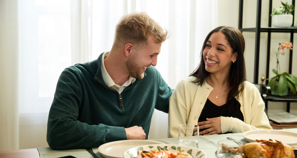 Young couple laughing together at dinner table