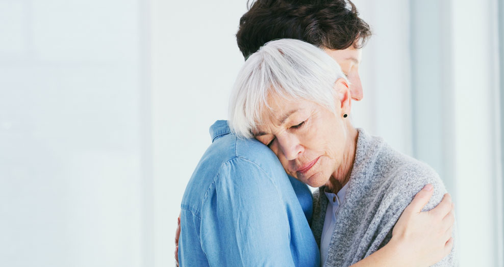 Women hugging in bright room